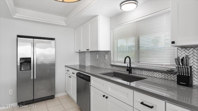 kitchen with stainless steel appliances, a sink, backsplash, dark countertops, and a raised ceiling