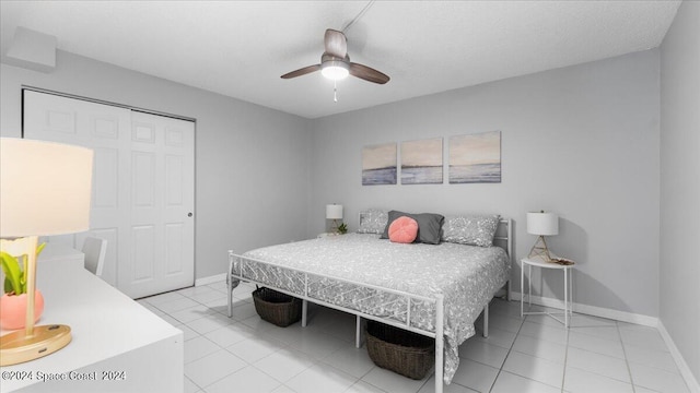 tiled bedroom featuring ceiling fan and a closet