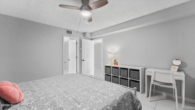 tiled bedroom featuring a ceiling fan, visible vents, and a textured ceiling