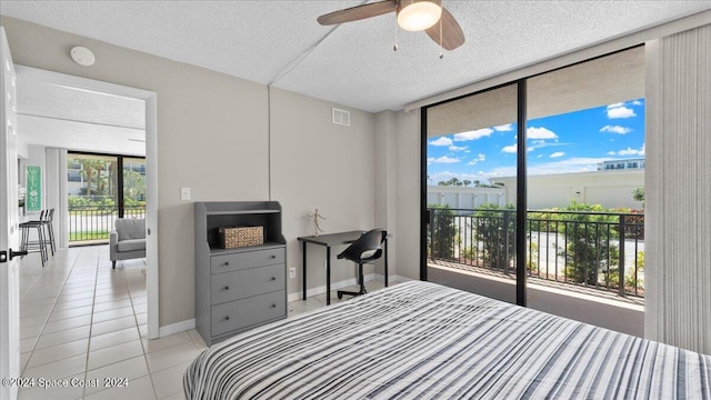 bedroom with a textured ceiling, light tile patterned floors, access to outside, ceiling fan, and expansive windows