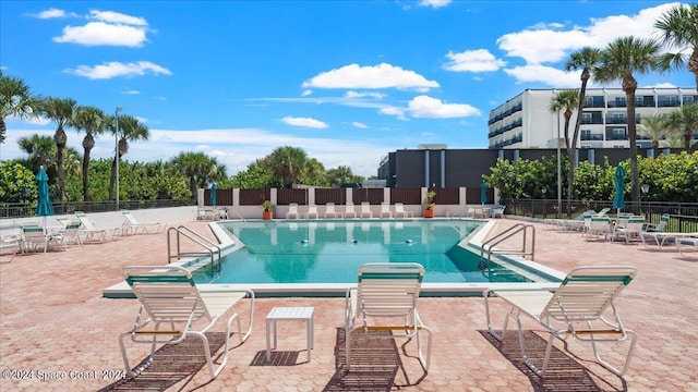 pool featuring fence and a patio