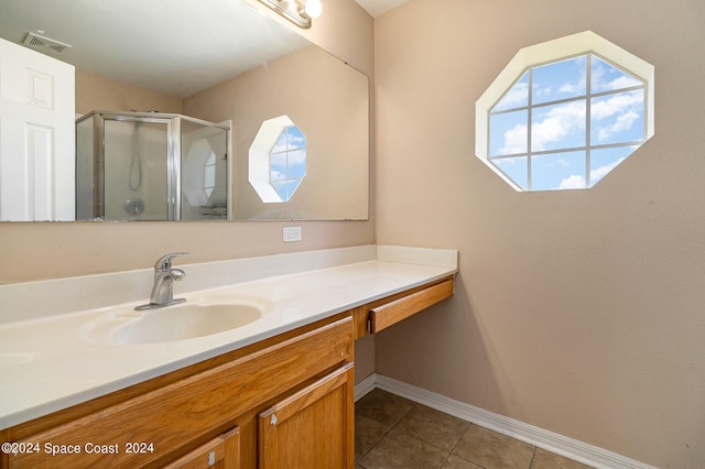 bathroom featuring vanity, a shower with door, and tile patterned flooring