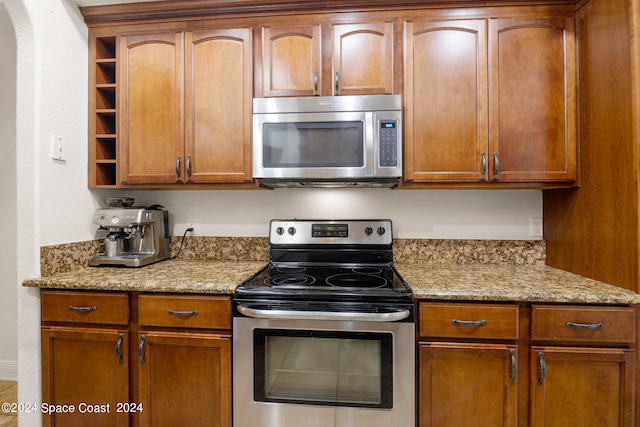 kitchen with light stone countertops and stainless steel appliances