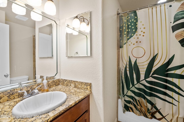 full bathroom with toilet, shower / bath combo with shower curtain, and vanity