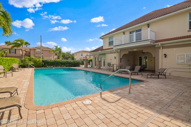 view of swimming pool featuring ceiling fan and a patio area