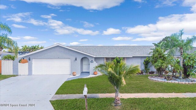 ranch-style home with a garage and a front lawn