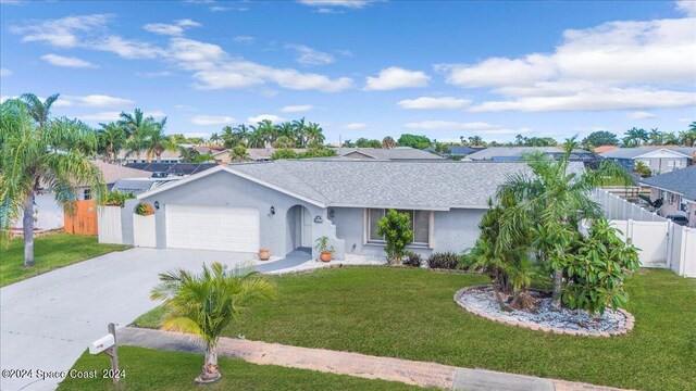 ranch-style home featuring a garage and a front lawn