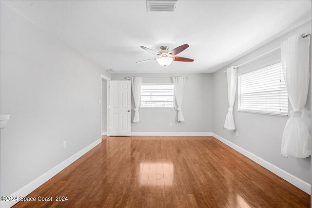 spare room with ceiling fan and wood-type flooring