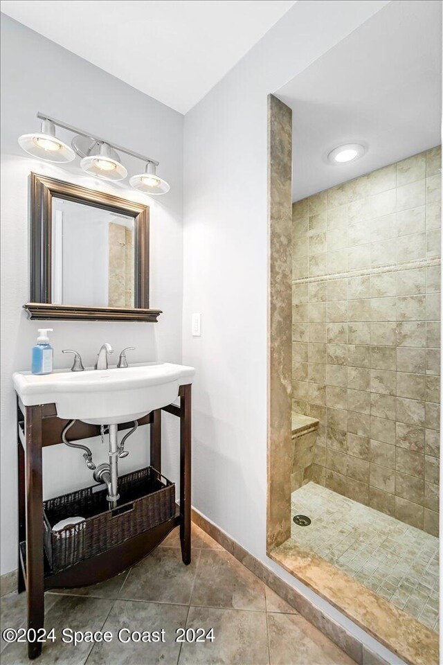 bathroom featuring tile patterned flooring and a tile shower