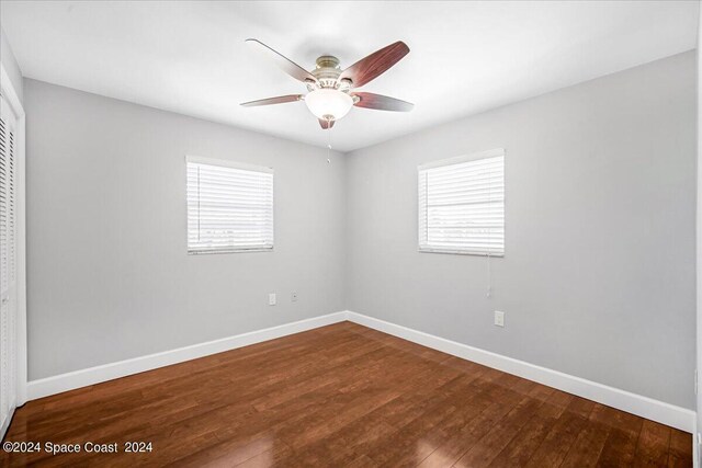 empty room with ceiling fan, plenty of natural light, and hardwood / wood-style floors