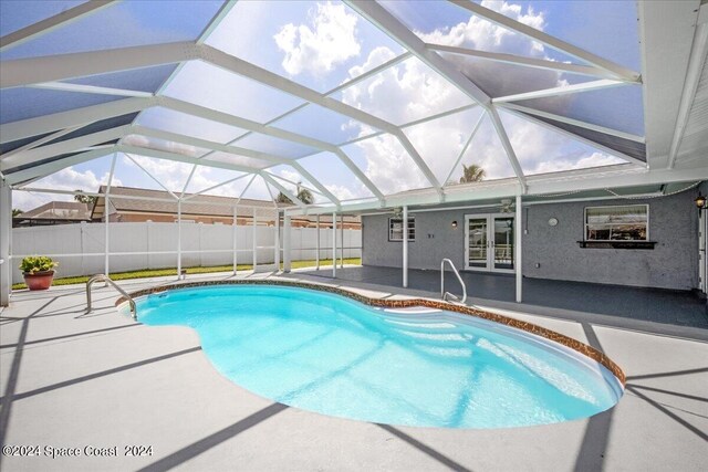 view of swimming pool featuring a patio, french doors, and a lanai