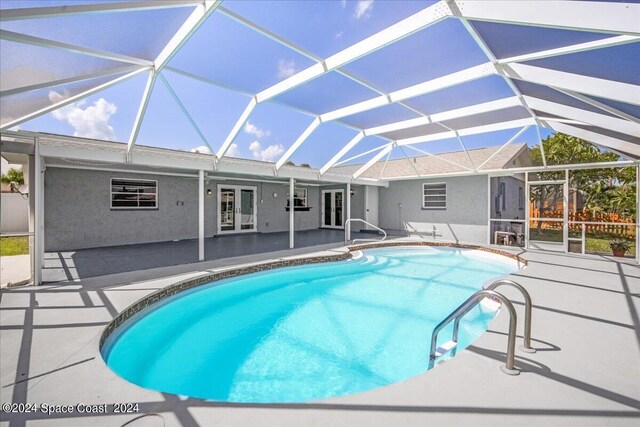 view of swimming pool with a patio, french doors, and a lanai