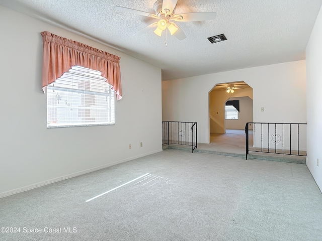 spare room featuring ceiling fan, a textured ceiling, and a wealth of natural light