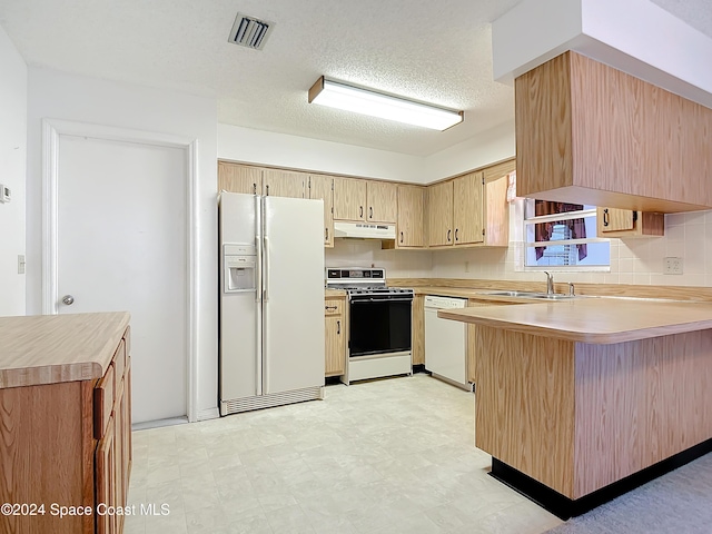 kitchen with sink, decorative backsplash, white appliances, kitchen peninsula, and a textured ceiling