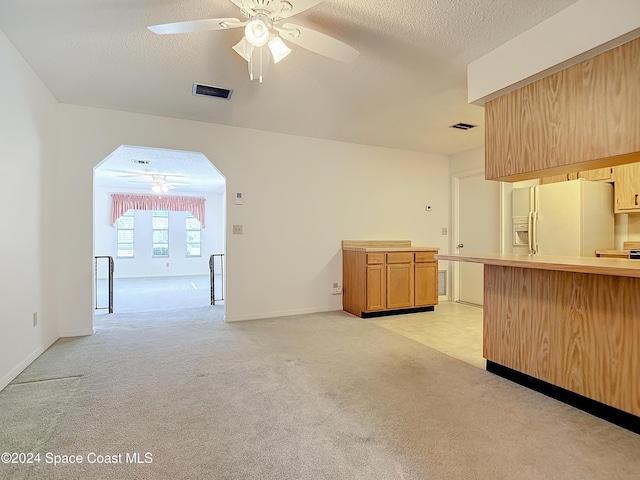 kitchen featuring white fridge with ice dispenser, light carpet, a textured ceiling, and ceiling fan