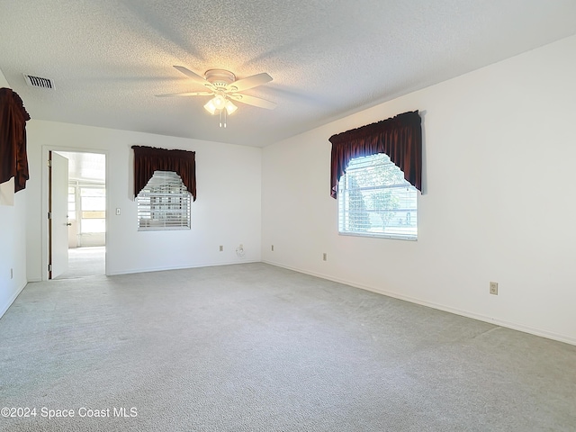 spare room with light carpet, a textured ceiling, and ceiling fan