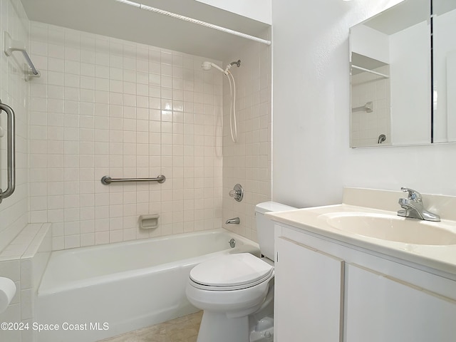 full bathroom featuring vanity, tiled shower / bath, and toilet