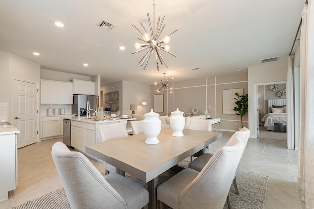 tiled dining area with a chandelier and sink