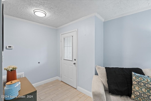 foyer featuring baseboards, light wood finished floors, a textured ceiling, and crown molding