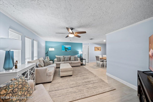 living room with a textured ceiling, ornamental molding, light wood-style flooring, and a ceiling fan