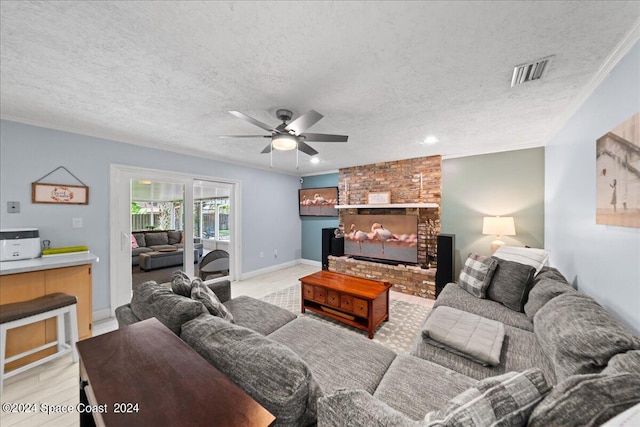 living room featuring a textured ceiling, ceiling fan, visible vents, baseboards, and ornamental molding