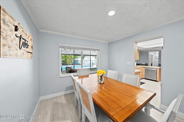 dining area with a textured ceiling, crown molding, light wood-type flooring, and baseboards