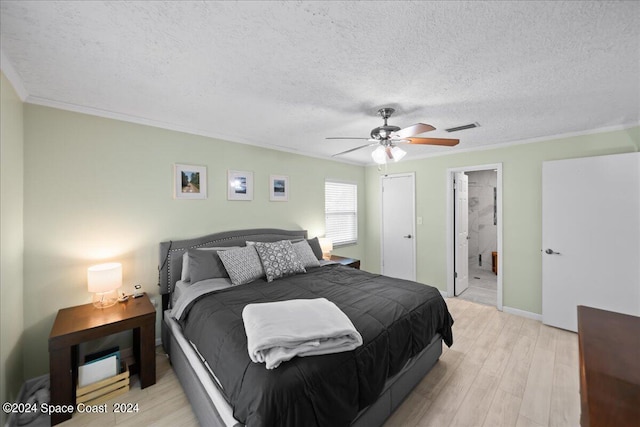 bedroom featuring ornamental molding, visible vents, a textured ceiling, and light wood finished floors