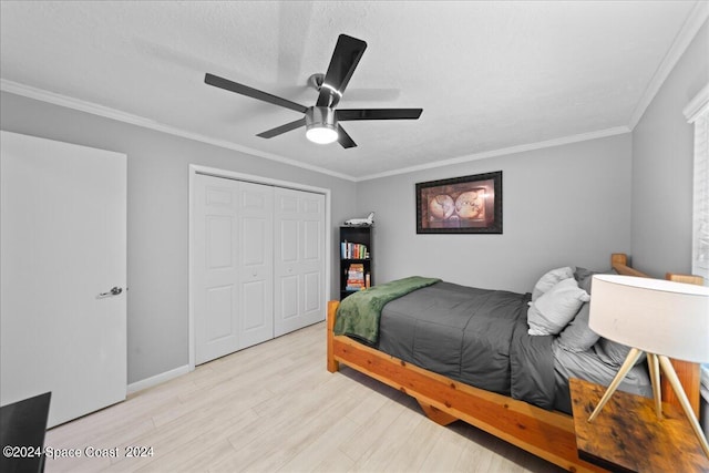 bedroom with light wood finished floors, ceiling fan, ornamental molding, a textured ceiling, and a closet