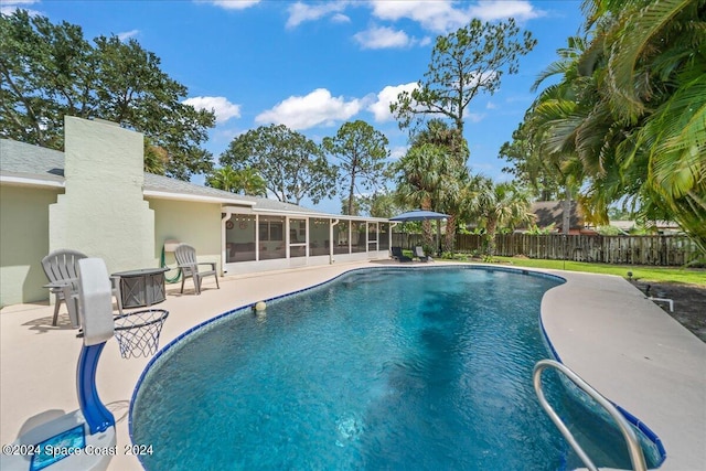 view of swimming pool with a patio area, fence, a sunroom, and a fenced in pool