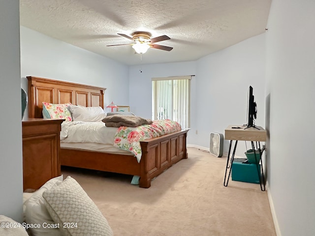 carpeted bedroom with ceiling fan and a textured ceiling