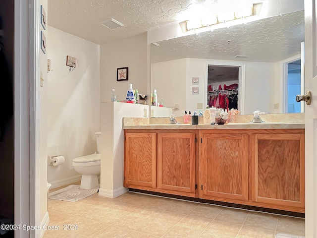 bathroom featuring vanity, a textured ceiling, and toilet