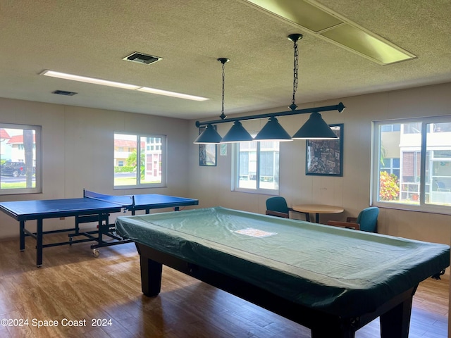 playroom with hardwood / wood-style flooring, a textured ceiling, and a healthy amount of sunlight