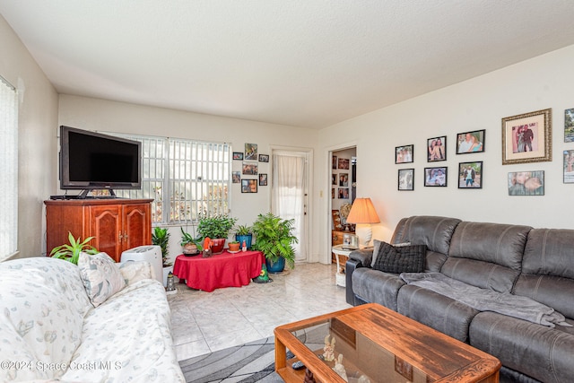 living room featuring a textured ceiling and light tile patterned floors