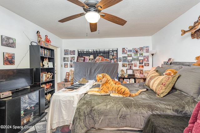 bedroom with ceiling fan and a textured ceiling