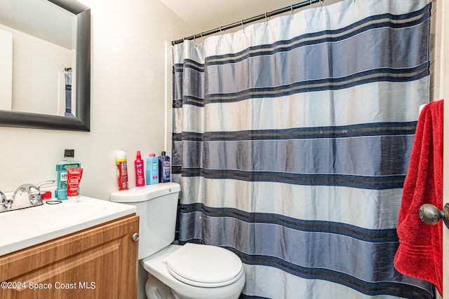 bathroom with toilet, a shower with shower curtain, and vanity