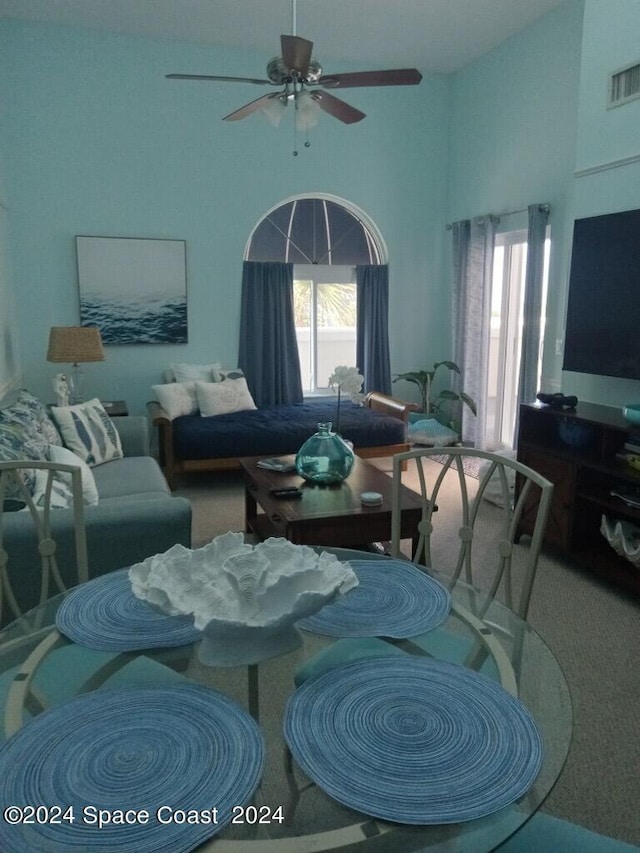 8600 Ridgewood Ave N Unit 1313, Cape Canaveral, FL 32920 - carpeted living area featuring healthy amount of natural light, a ceiling fan, and a high ceiling
