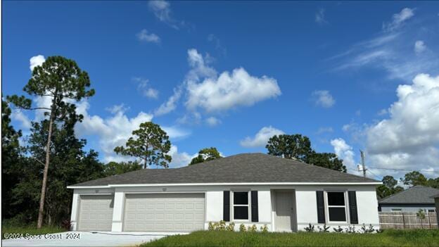 ranch-style home with a garage, driveway, and fence