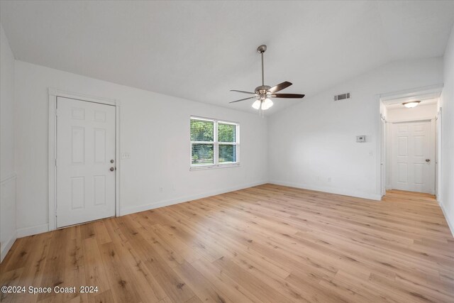 empty room featuring ceiling fan, lofted ceiling, and light wood-type flooring