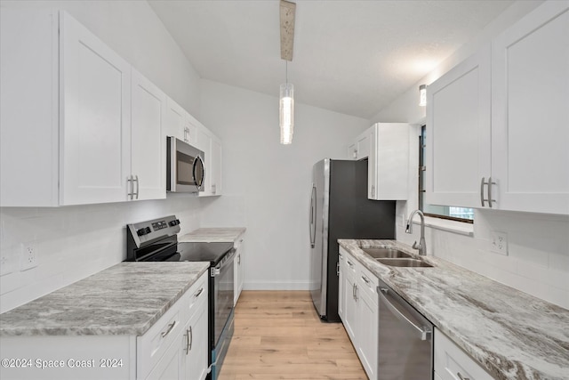 kitchen featuring stainless steel appliances, hanging light fixtures, sink, white cabinets, and decorative backsplash