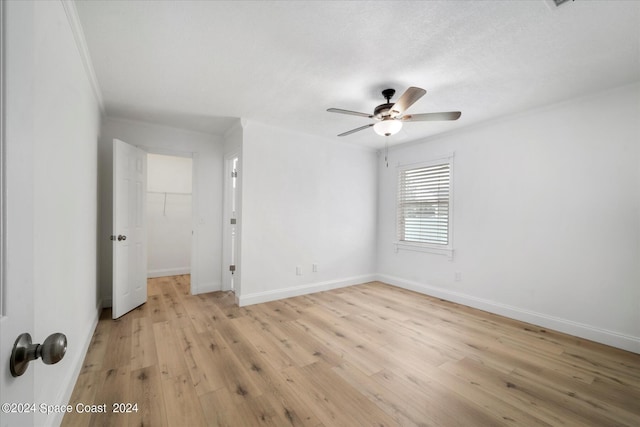 empty room featuring ceiling fan, a textured ceiling, and light hardwood / wood-style floors