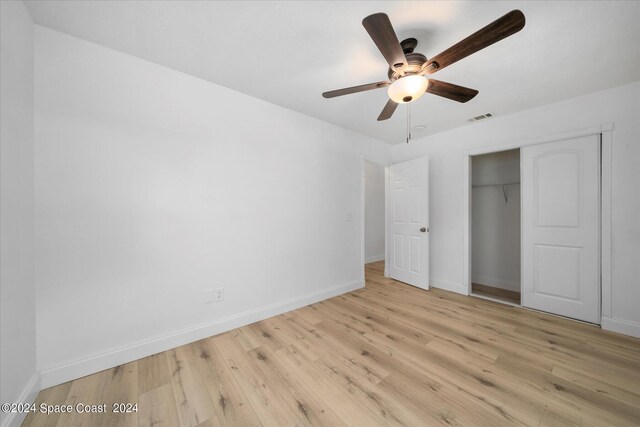 unfurnished bedroom with ceiling fan, a closet, and light hardwood / wood-style floors