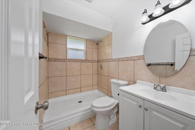 bathroom featuring ornamental molding, toilet, tile walls, a tile shower, and vanity