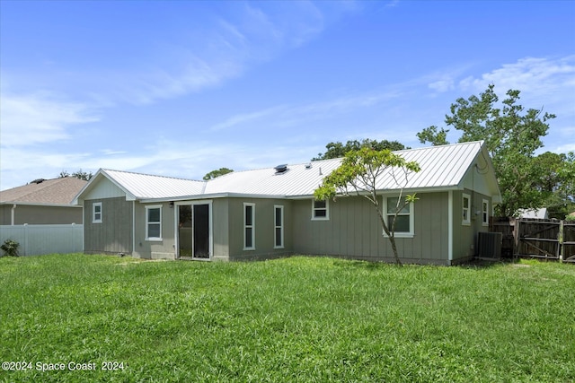 back of property with cooling unit and a yard