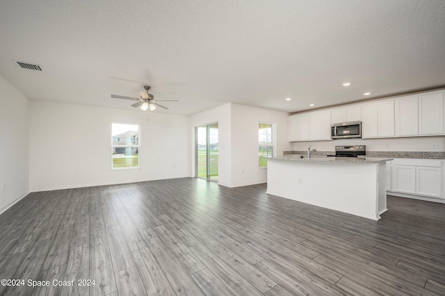 kitchen with stainless steel appliances, a sink, visible vents, white cabinetry, and open floor plan