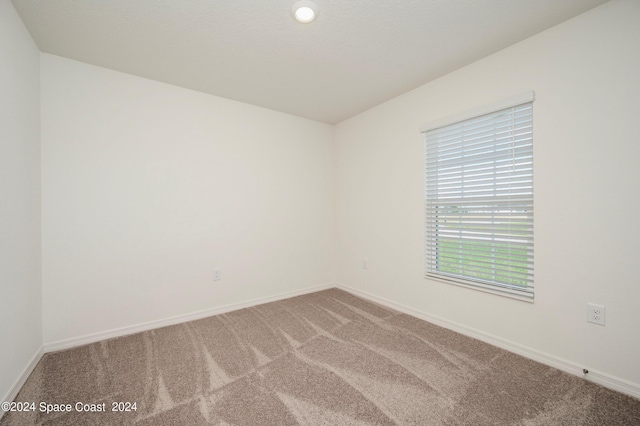 carpeted spare room with baseboards