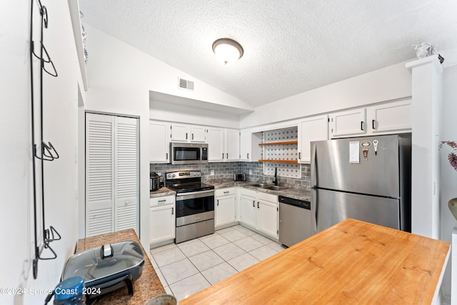 kitchen with tasteful backsplash, white cabinetry, and appliances with stainless steel finishes