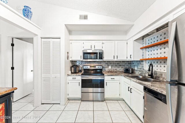 kitchen with sink, decorative backsplash, lofted ceiling, and stainless steel appliances