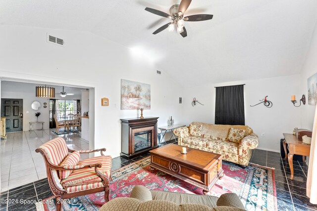 living room featuring ceiling fan, tile patterned floors, and lofted ceiling