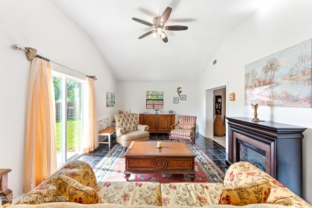 tiled living room with ceiling fan and high vaulted ceiling