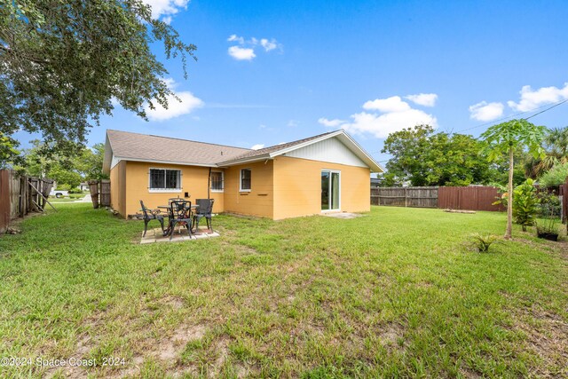 back of house with a lawn